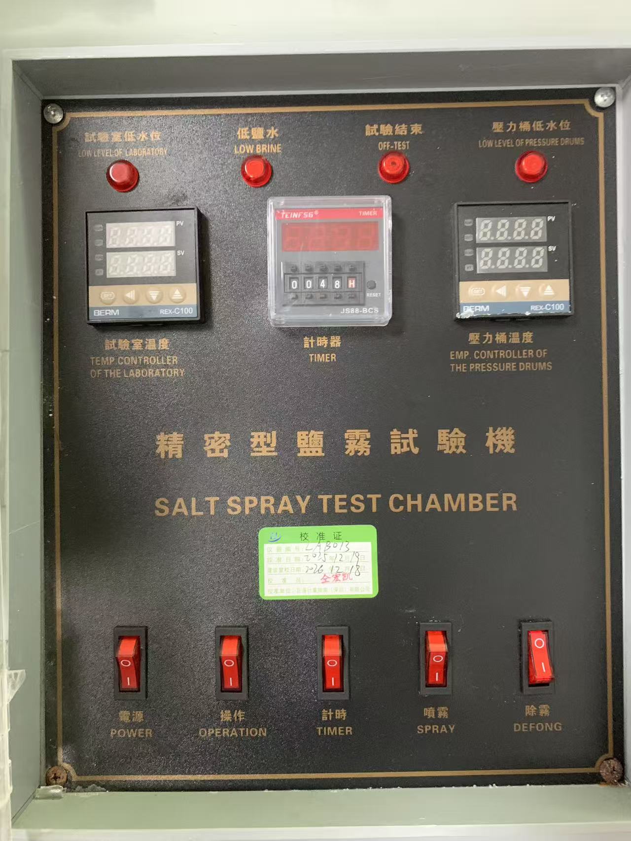Control panel of the salt spray chamber showing water level indicators, dual temperature controllers, timer and function switches